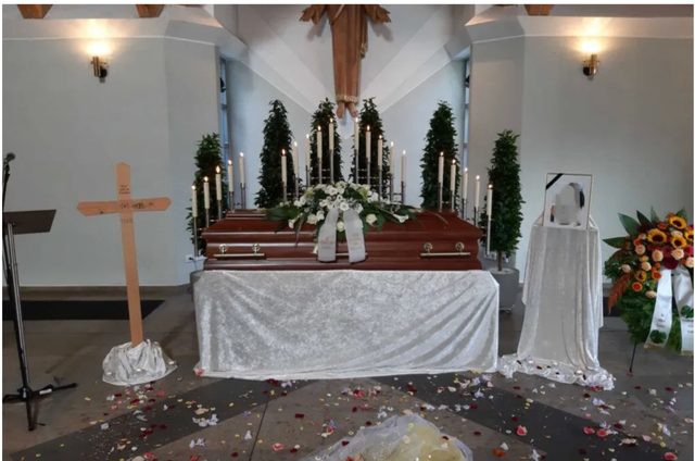 Aufgebahrter Sarg mit Blumenschmuck bei einer Trauerfeier von Pietät Tron